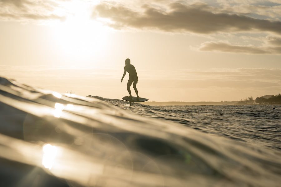 Girl surfing in sunset